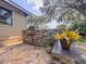 Outdoor kitchen with stone veneer, stainless steel grill, and lush landscaping at 3664 Se 45Th Pl, Ocala, FL 34480