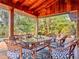 Charming outdoor patio with wood ceiling, dining set, string lights, and lush landscaping at 3664 Se 45Th Pl, Ocala, FL 34480