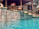 Inviting pool with waterfall feature, stone surround, and cozy seating area with beautiful view of the backyard at 3664 Se 45Th Pl, Ocala, FL 34480