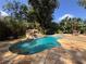 Beautiful pool with rock waterfall, stone patio, and lush, mature landscaping at 3664 Se 45Th Pl, Ocala, FL 34480