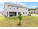 The backyard features green lawn, a covered patio with furniture, and a view of neighboring homes at 391 Cheeota Ct, Minneola, FL 34715