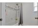 Bright, white bathroom with shower featuring wall tiling and modern shower head fixture at 391 Cheeota Ct, Minneola, FL 34715