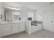 Bright bathroom featuring a tub, white cabinets, quartz countertop and tile flooring at 391 Cheeota Ct, Minneola, FL 34715