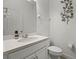 Half bath with white cabinet, countertop, leafy wall decor, and brushed metal faucet at 391 Cheeota Ct, Minneola, FL 34715