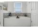 Bright bathroom featuring a large tub with tile surround and a window for natural light at 391 Cheeota Ct, Minneola, FL 34715