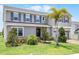 Beautifully landscaped two-story home, featuring blue shutters, green lawn and palm tree at 391 Cheeota Ct, Minneola, FL 34715