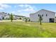 Bright exterior of a home with a large, green lawn and neat landscaping, adjacent houses complete the neighborhood view at 391 Cheeota Ct, Minneola, FL 34715