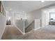 Upstairs hallway with carpet, stairway, and view into sitting area with desk at 391 Cheeota Ct, Minneola, FL 34715