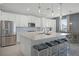 Contemporary kitchen with a large island, white cabinetry, and stainless steel appliances at 391 Cheeota Ct, Minneola, FL 34715