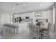 Modern kitchen with island seating, stainless steel appliances, and adjacent dining area at 391 Cheeota Ct, Minneola, FL 34715
