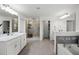 Bright main bathroom features dual vanities, a walk-in shower, and a soaking tub at 391 Cheeota Ct, Minneola, FL 34715