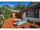 Charming backyard featuring a blue bench, seating area, and beautiful landscaping with tropical plants at 4219 Magnolia Ave, Leesburg, FL 34748