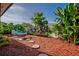 Lush backyard oasis with a stone walkway, blue seating, and a variety of plants and greenery at 4219 Magnolia Ave, Leesburg, FL 34748