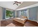 Bright bedroom with hardwood floors, sliding doors to the backyard and a ceiling fan at 4219 Magnolia Ave, Leesburg, FL 34748