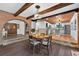 Elegant dining room showcasing hardwood floors, a brick archway, and a view into the modern kitchen at 4219 Magnolia Ave, Leesburg, FL 34748