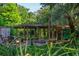 Waterfront dock with seating area under wood canopy and surrounded by lush landscaping on a sunny day at 4219 Magnolia Ave, Leesburg, FL 34748