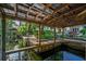 Waterfront dock with wood canopy and ladder entry to the water at 4219 Magnolia Ave, Leesburg, FL 34748