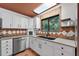 Bright kitchen features white cabinetry, granite countertops, stainless steel appliances, and a window at 4219 Magnolia Ave, Leesburg, FL 34748