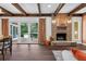 Cozy living room with a brick fireplace, wood beams, and sliding doors to the outside patio at 4219 Magnolia Ave, Leesburg, FL 34748