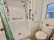 Bathroom featuring walk in shower, grab bars, storage and toilet near window at 424 Hawthorne Blvd, Leesburg, FL 34748
