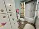 Bathroom showing a shower-tub combination, toilet, and cabinet with butterfly decorations at 424 Hawthorne Blvd, Leesburg, FL 34748