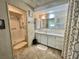 Neutral bathroom featuring a walk in shower, full vanity, large mirror and tiled walls at 424 Hawthorne Blvd, Leesburg, FL 34748
