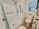 Bathroom featuring walk in shower, grab bars, and toilet near window at 424 Hawthorne Blvd, Leesburg, FL 34748