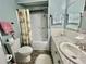 Bathroom featuring white cabinets, marble countertop, and a shower-tub combo at 424 Hawthorne Blvd, Leesburg, FL 34748