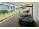 A well-kept carport featuring a golf cart and a partial view of the property at 424 Hawthorne Blvd, Leesburg, FL 34748