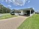 Quaint single-story residence featuring manicured landscaping, a golf cart, and a carport at 424 Hawthorne Blvd, Leesburg, FL 34748
