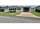 Inviting single-story home showcasing manicured lawn, a golf cart, and a convenient carport at 424 Hawthorne Blvd, Leesburg, FL 34748