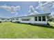 Charming home exterior featuring vinyl siding, awning windows, and a well-maintained lawn at 424 Hawthorne Blvd, Leesburg, FL 34748