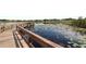 Scenic community lake featuring a wooden pier, lily pads, and water reflections at 5008 Sawgrass Lake Cir, Leesburg, FL 34748