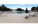 Community pool with lounge chairs and blue umbrellas at 5008 Sawgrass Lake Cir, Leesburg, FL 34748
