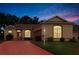 Charming single-story home featuring a brick driveway, well-manicured lawn, and lovely landscaping at 5008 Sawgrass Lake Cir, Leesburg, FL 34748
