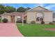 Charming single-story home featuring a brick driveway, well-manicured lawn, and lovely landscaping at 5008 Sawgrass Lake Cir, Leesburg, FL 34748