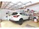 Spacious garage featuring storage shelves and car at 5008 Sawgrass Lake Cir, Leesburg, FL 34748