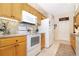 Functional kitchen with white appliances, ample counter space, and warm-toned cabinetry at 5008 Sawgrass Lake Cir, Leesburg, FL 34748