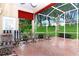 Relaxing screened lanai featuring a brick floor, comfortable seating, and views of the lush backyard at 5008 Sawgrass Lake Cir, Leesburg, FL 34748