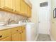 Well-equipped laundry room with washer, dryer, sink, and ample storage cabinets for convenience at 5008 Sawgrass Lake Cir, Leesburg, FL 34748