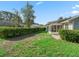 Manicured backyard featuring a screened-in porch and lush green hedges, creating a private oasis at 512 Galloway Ct, Leesburg, FL 34788