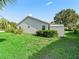 The backyard features green grass, a shed, and well-maintained hedges with blue skies above at 512 Galloway Ct, Leesburg, FL 34788