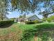 Large backyard shows a screened-in porch, lush greenery, and an overall sense of tranquility at 512 Galloway Ct, Leesburg, FL 34788