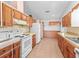 Kitchen featuring tile floor, wood cabinets, and white appliances at 512 Galloway Ct, Leesburg, FL 34788