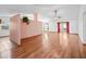 Open-concept living room with hardwood floors, ceiling fan, and abundant natural light at 512 Galloway Ct, Leesburg, FL 34788