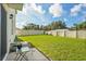 Large, grassy backyard enclosed by a white fence, offering ample space and clear blue skies above at 5386 Pine Lilly Dr, St Cloud, FL 34771