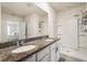 Modern bathroom featuring double sinks, granite countertops, a walk-in shower, and modern fixtures at 5386 Pine Lilly Dr, St Cloud, FL 34771