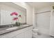 Bathroom with double vanity, granite counters, and a shower-tub combination behind a white shower curtain at 5386 Pine Lilly Dr, St Cloud, FL 34771