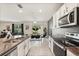Modern open-plan kitchen featuring stainless steel appliances, granite countertops, and a dining area at 5386 Pine Lilly Dr, St Cloud, FL 34771