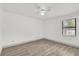 Bright bedroom features wood-look flooring, a ceiling fan, and window at 5390 Nw 12Th Pl, Ocala, FL 34482